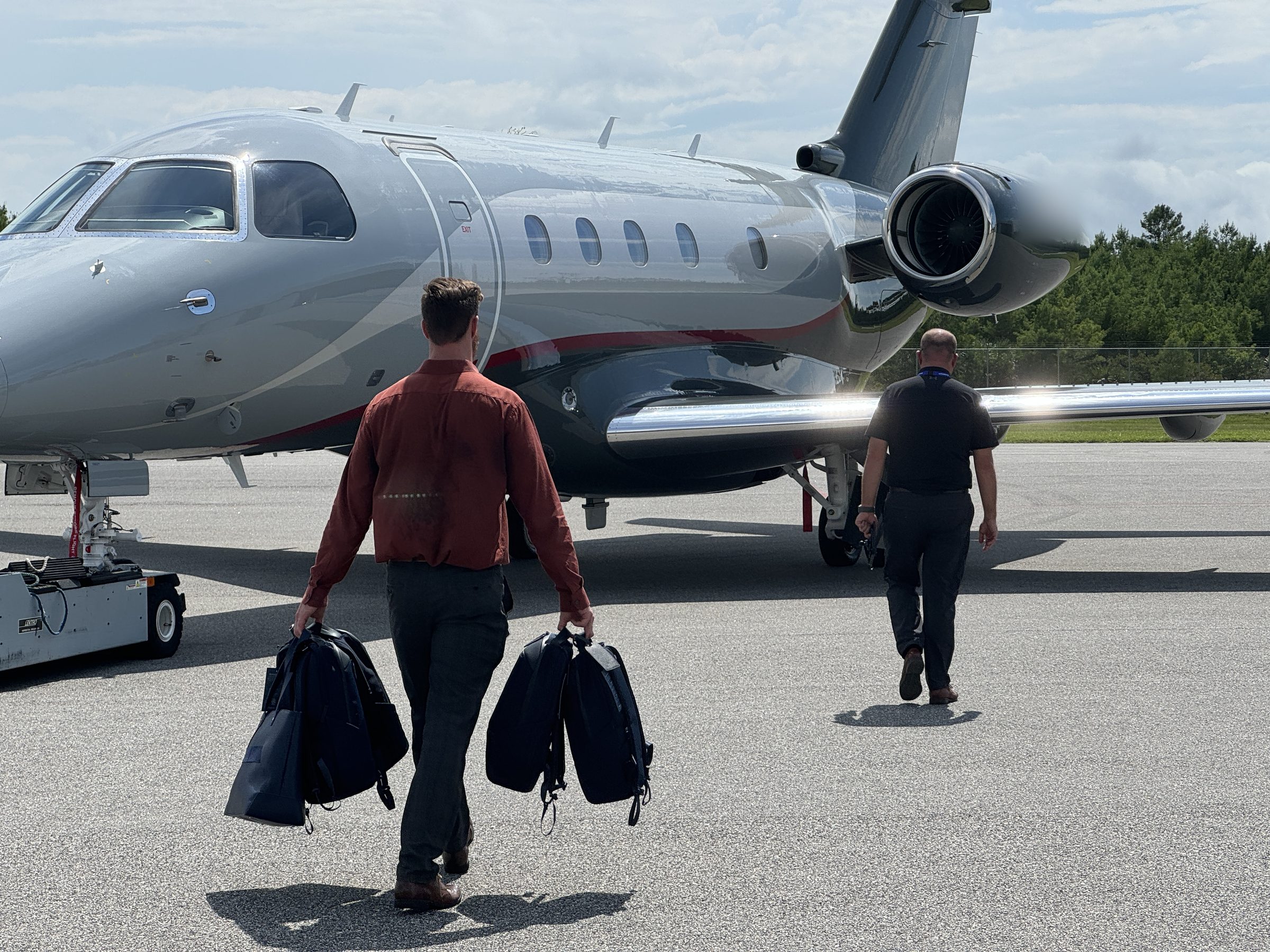 Crew walking out to a business jet with bags